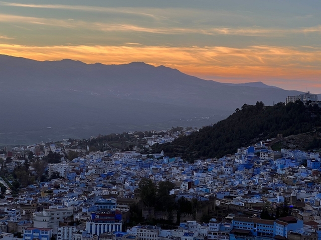       Panoramic view of mountain and city at sunset
  