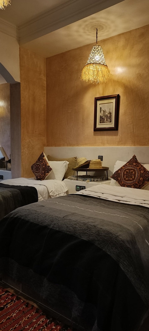       Elegant hotel room with colorful cushions and traditional hats.
  