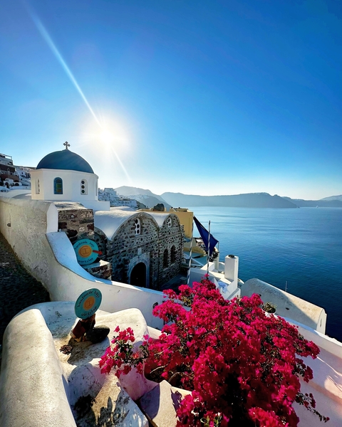       Iconic view of Santorini with a blue-domed church and sea.
  