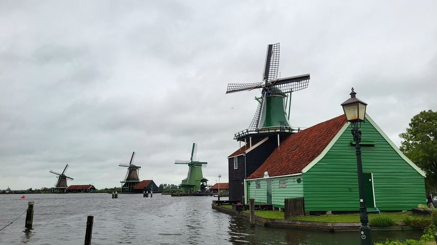 Scenic view of traditional windmills by the water.