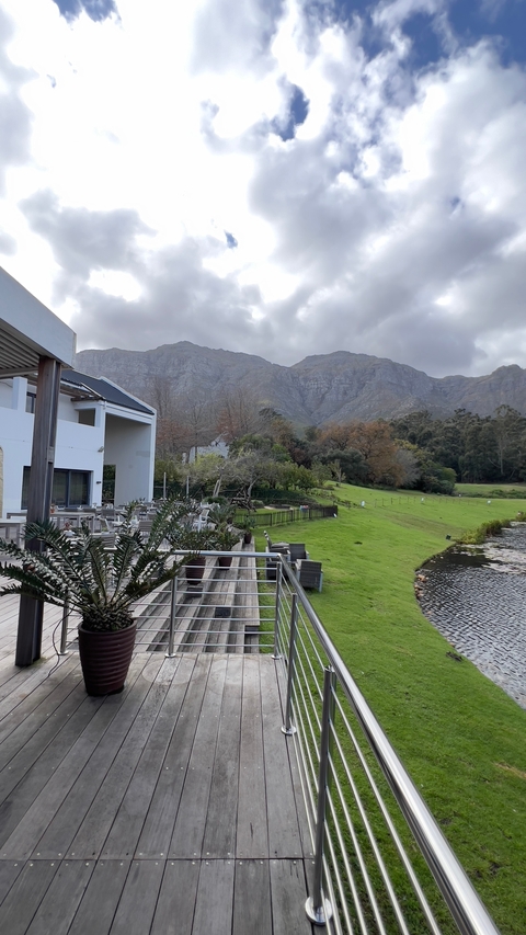 House with mountain backdrop in a rural setting.
