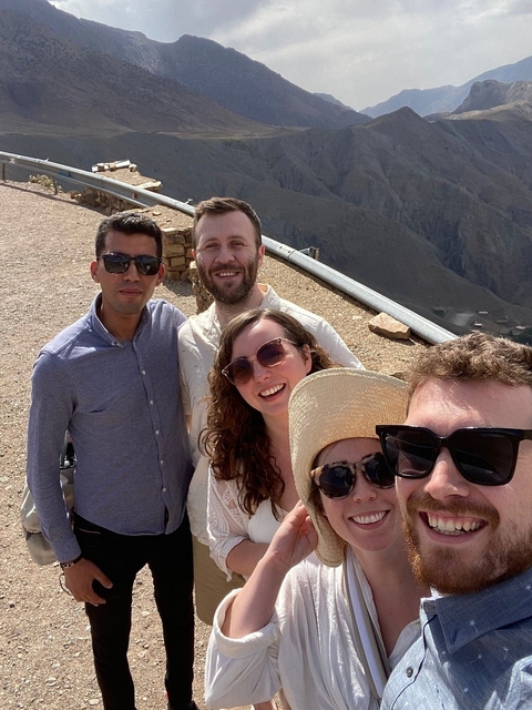       Group selfie with tourists in a desert environment.
  