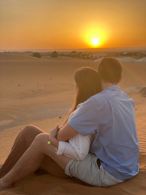       Couple enjoying the sunset in the desert.
  