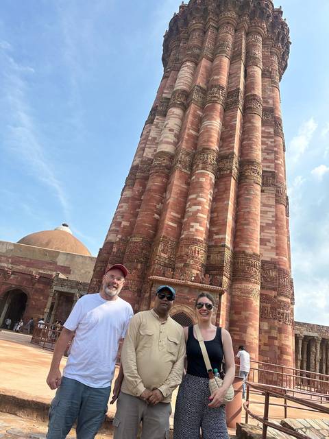       Tourists posing in front of Qutub Minar.
  