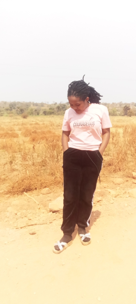      Person standing in a dry grass field wearing a t-shirt.
  