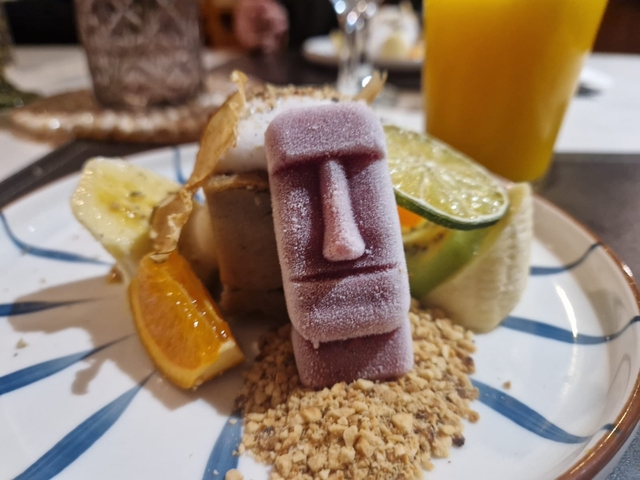 Dessert modeled after a Moai statue with assorted fruits.