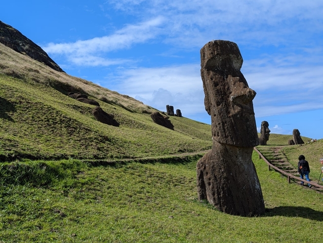 Pathway among Moai statues on a hillside.