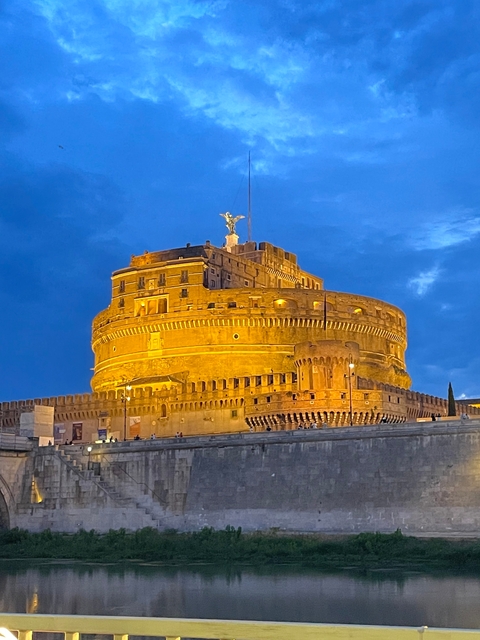       A night view of Castel Sant'Angelo illuminated by lights.
  