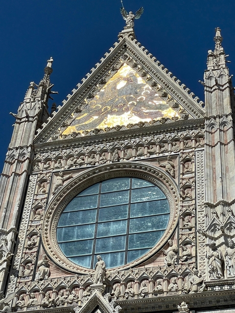       A close-up of a decorative facade with a large window.
  
