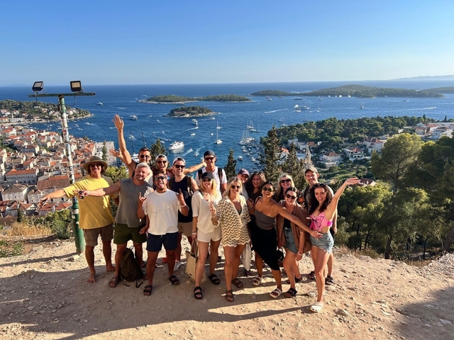       Group of people posing with a view of the coastline.
  