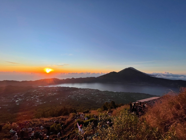       Sunset view over mountains and a lake.
  