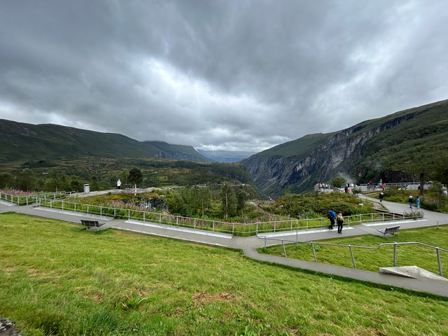       Tourists enjoying a mountainous landscape with observation deck.
  