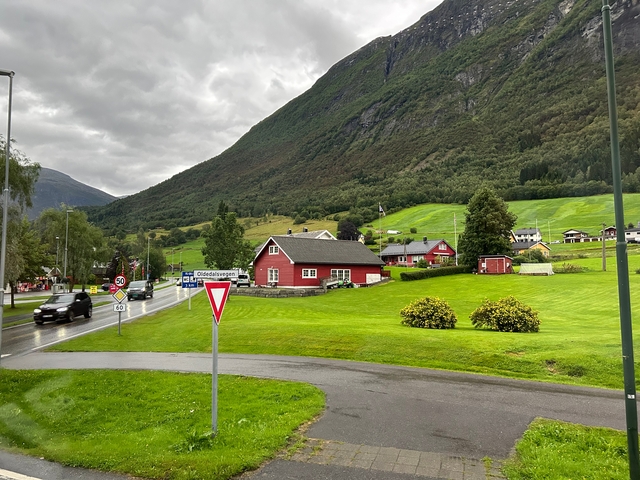       Rural community with cars and houses in a hilly area.
  