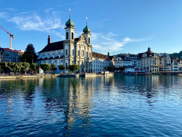 Beautiful lakeside view with historic buildings reflected in water.