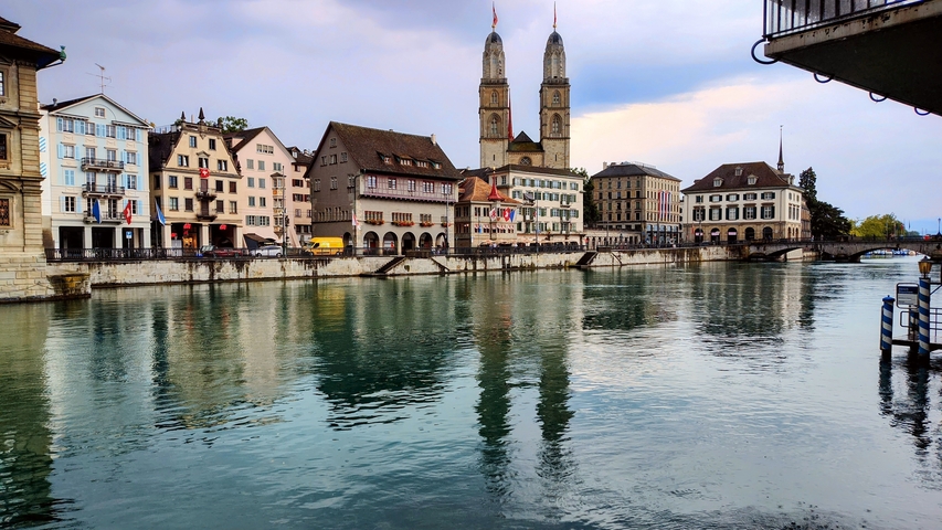 Picturesque waterfront with historic buildings reflected in the water.