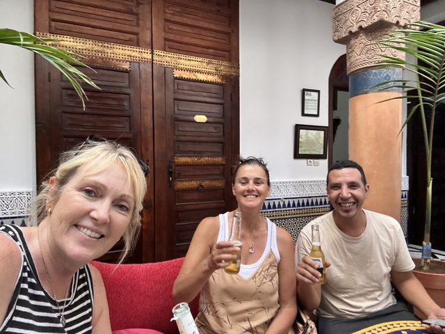 Three people sitting and enjoying drinks in a room with traditional décor.