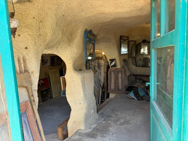 Interior of a cave-like room with various antique items and mirrors.