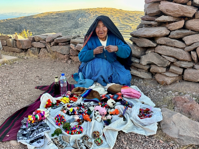       Vendor with traditional crafts and colorful items displayed.
  