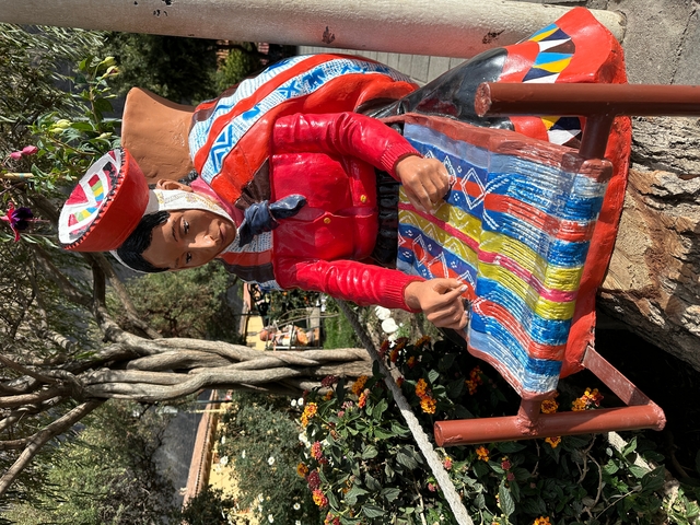       Colorful statue of a traditional figure with weaving.
  