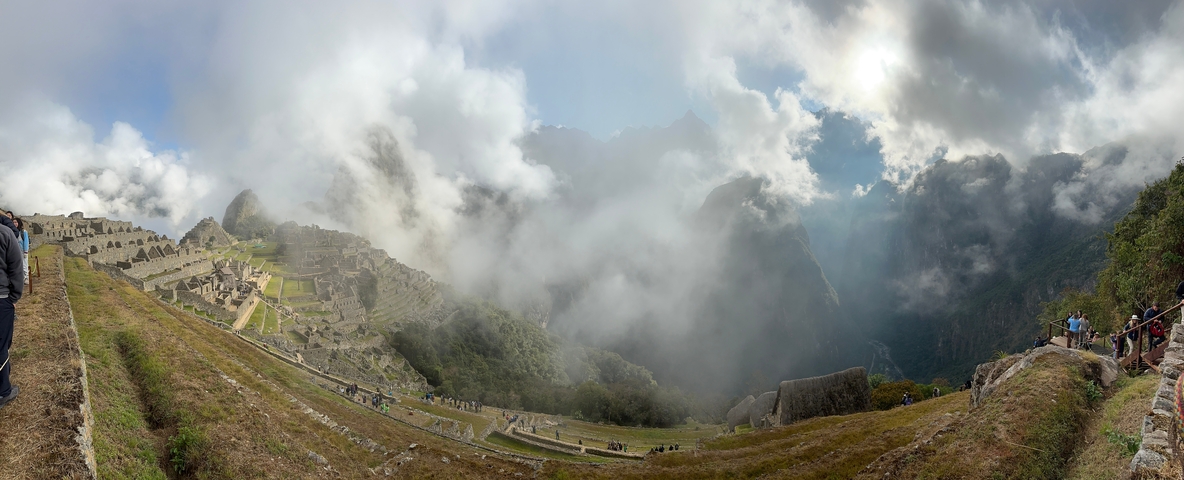       Panoramic view of Machu Picchu shrouded in clouds.
  