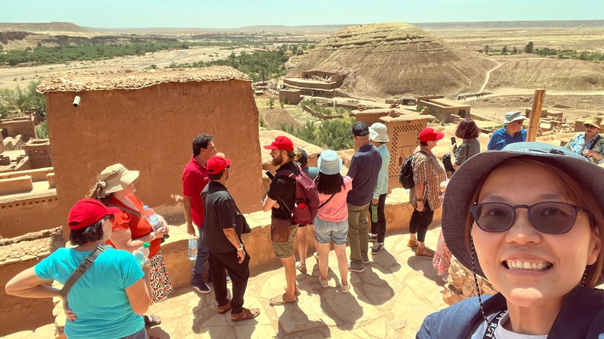       A group of tourists exploring a historic desert settlement.
  
