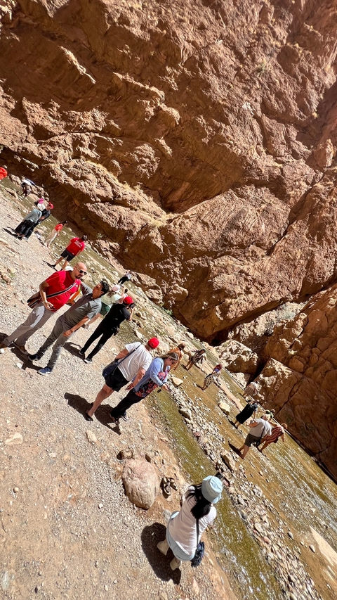       Tourists exploring a rocky canyon.
  