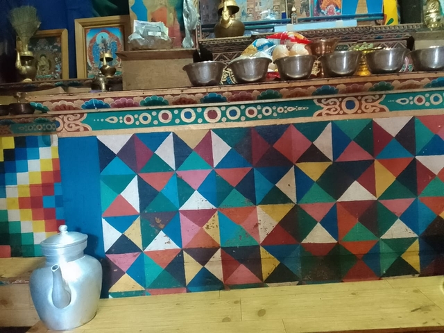Colorful geometric designs on a wall with traditional items.