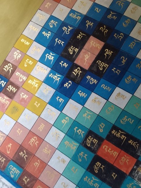 Colorfully painted tiles with text in an unknown script.