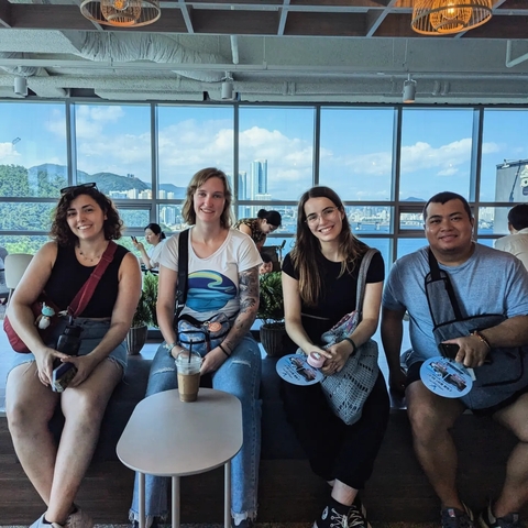Group of people sitting with a city view behind them.