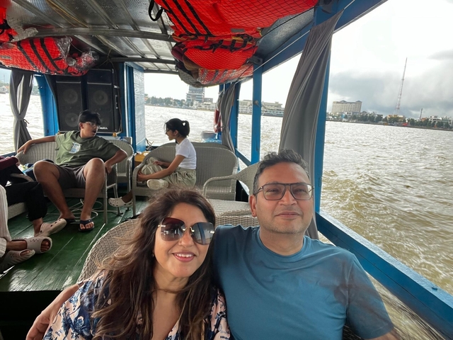      Couple on a boat ride with city view in the background.
  