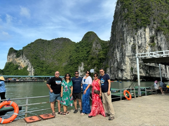 Group of people posing with large rock formations in the background.