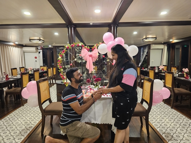       Couple at a romantic dinner setting with balloons and candles.
  