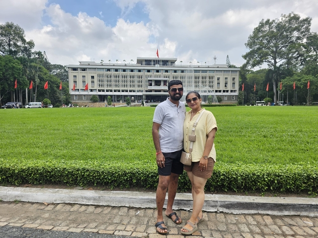       Couple posing in front of a government building with flags.
  