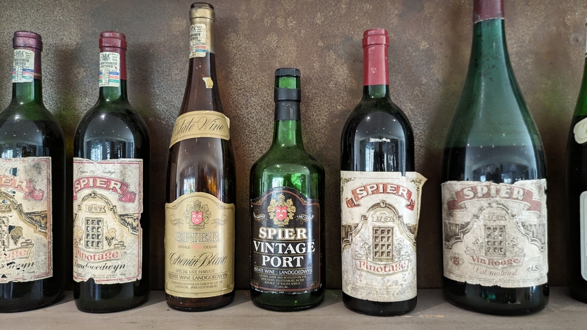 A row of vintage wine bottles on a shelf.