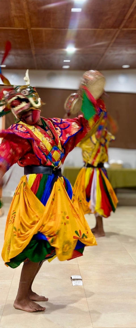       Two people in traditional Bhutanese costume dancing.
  