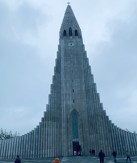 Church with a prominent tower under a cloudy sky.