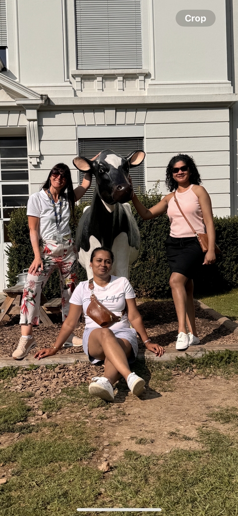       Three people posing with a large penguin statue.
  