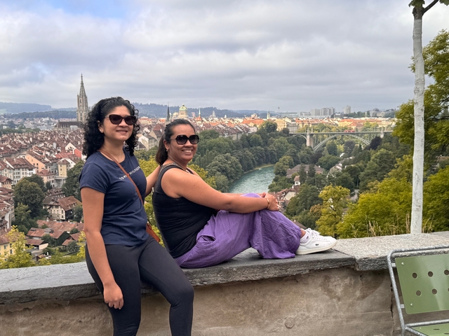 Two people sitting with a panoramic view of Bern.