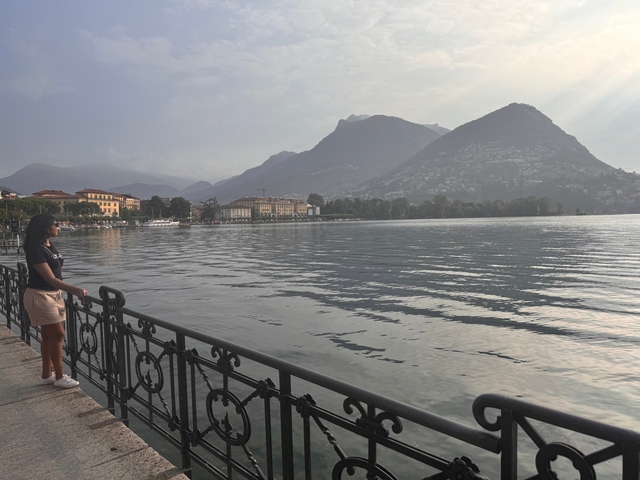 Person looking out over a scenic lake view.