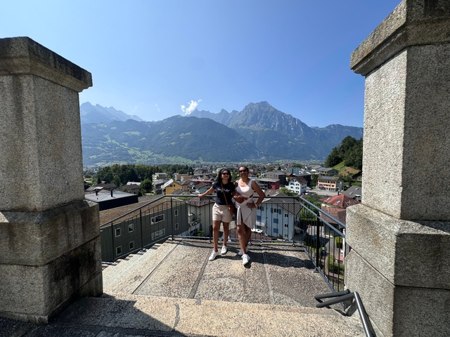       Two people posing with a mountain view.
  