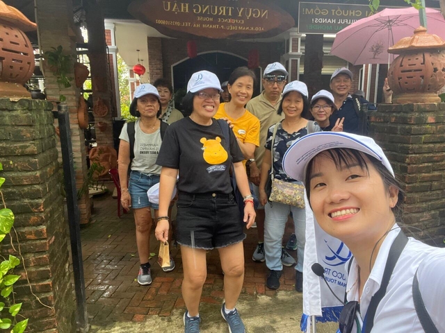       Group of tourists wearing caps posing outdoors.
  