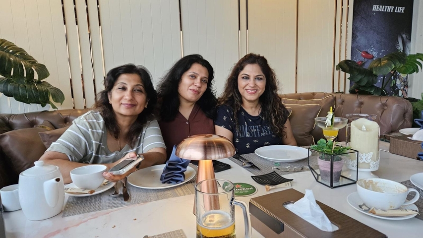       Three women sitting at a restaurant table after dining.
  