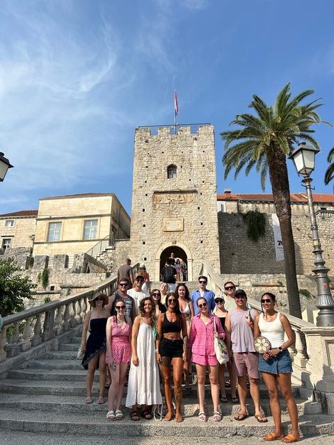 Group of people at the entrance of a historic stone building.