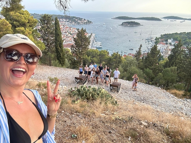 People posing with a panoramic view of the coastal town.
