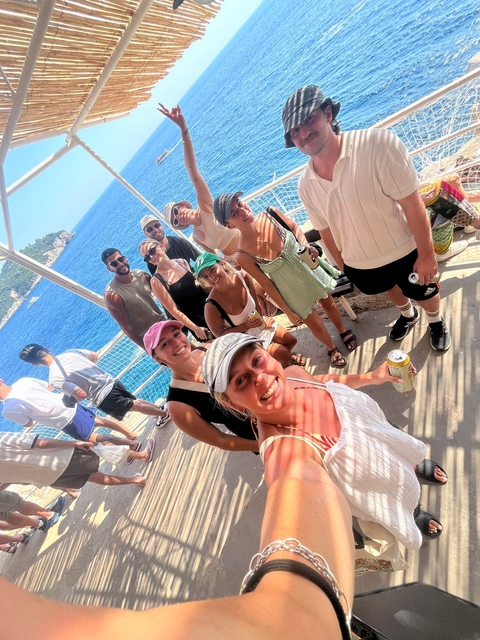 Group of friends standing on a coastal platform.