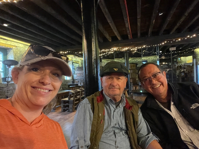       Group of people sitting inside a bar with wooden decor.
  