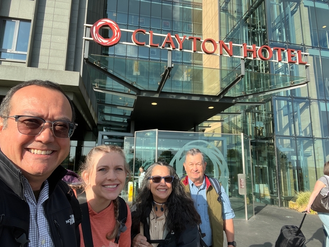 Group of people standing outside a hotel entrance.
