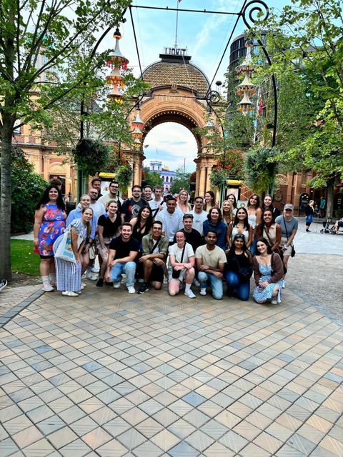       Group posing outdoors in a park.
  