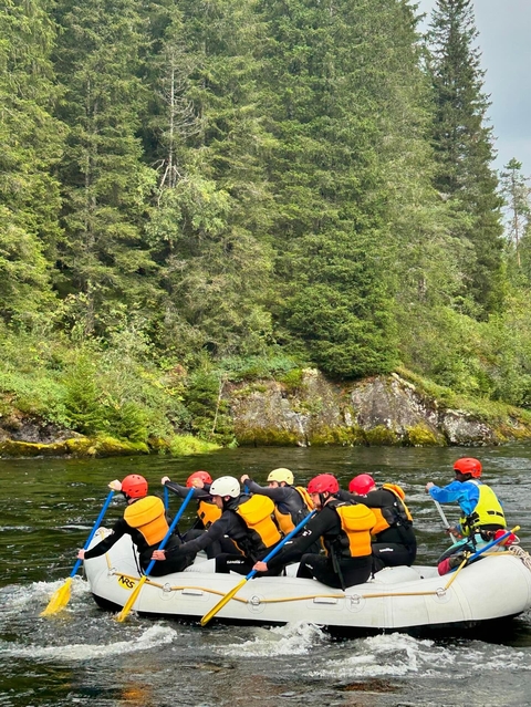       People rafting on a scenic river.
  