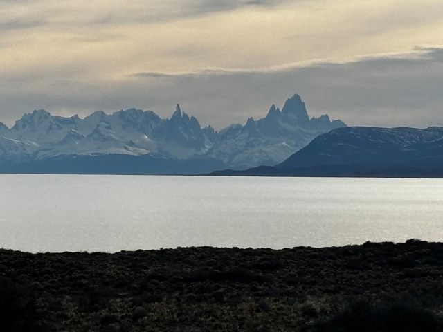 Mountain silhouettes above a large body of water.